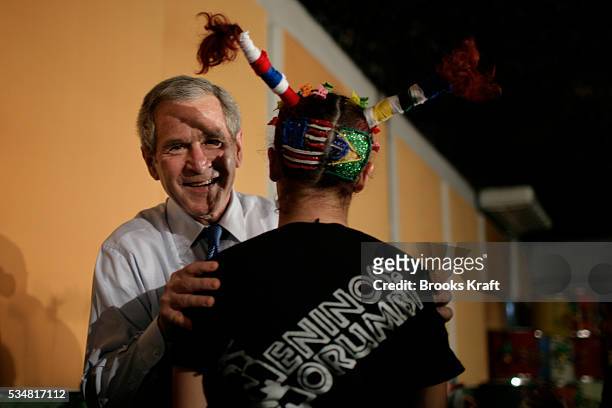 President George W. Bush looks at flags painted on the back of a Brazilian youth dancer at a performance at Meninos Do Morumbi Youth Community Center...