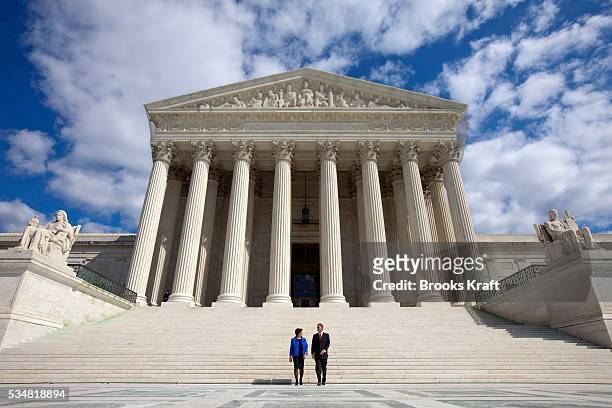 Justice Elena Kagan walks down the steps of the Supreme Court with Chief Justice of the United States John Roberts following her formal investiture...