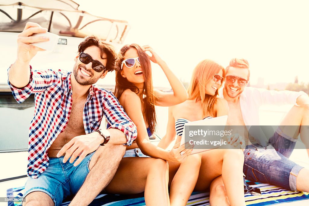 Fröhliche Freunde machen Selfie auf Yacht.