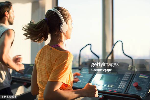 young people running on treadmill in a gym. - treadmill stock pictures, royalty-free photos & images