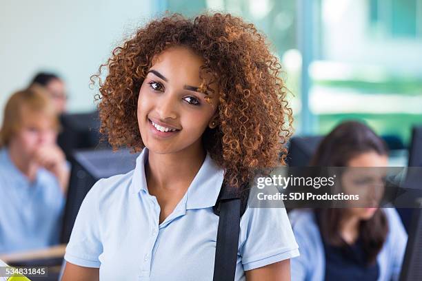 beautiful african american teen girl in private high school classroom - african american school uniform stock pictures, royalty-free photos & images