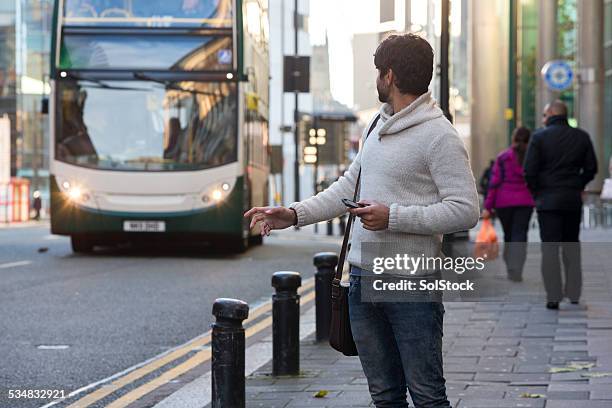 man waiting at the bus stop - bus stop uk stock pictures, royalty-free photos & images