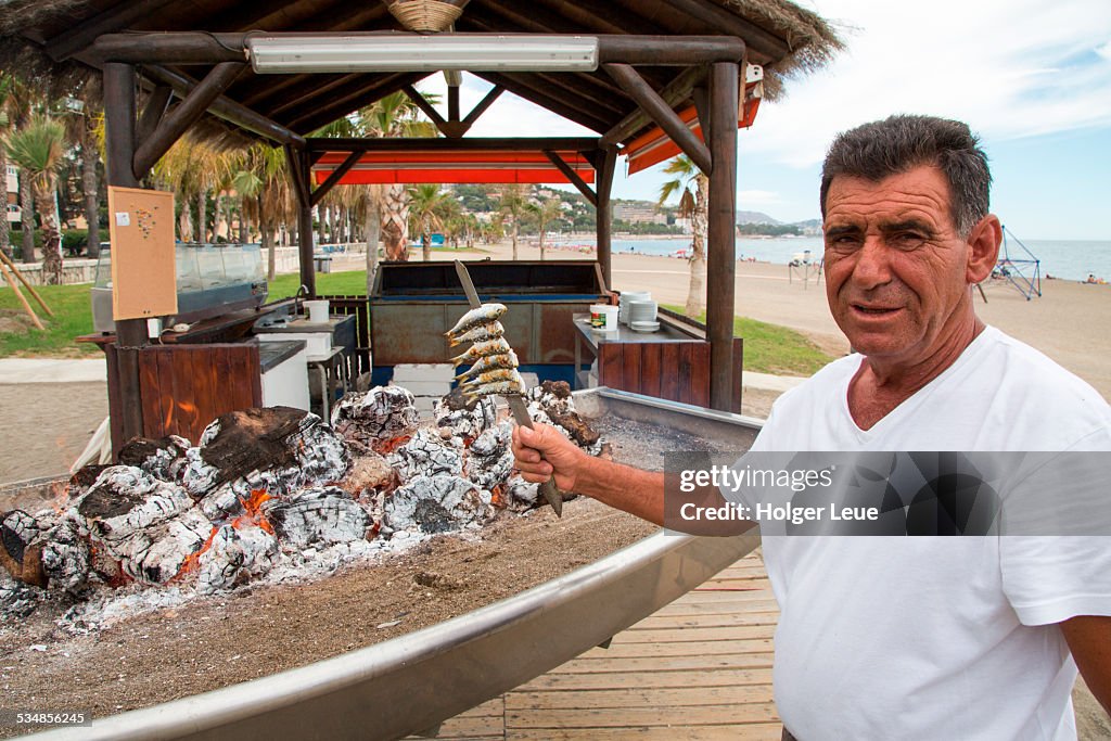 Sardines are grilled over charcoal at beach