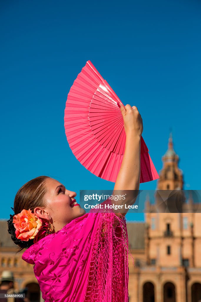 Young flamenco dancer holds fan at Plaza de Espana
