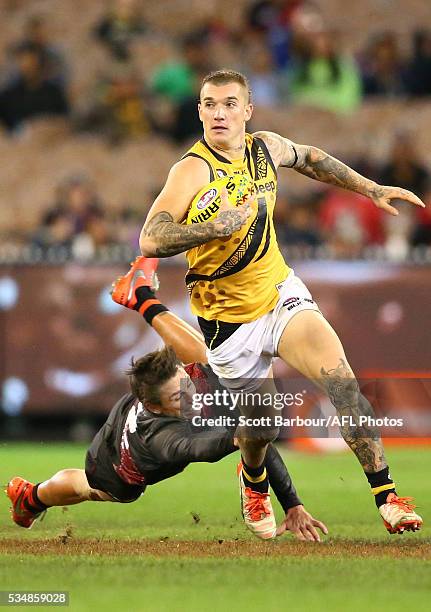 Dustin Martin of the Tigers beats the tackle of Mark Baguley of the Bombers during the 2016 AFL Round 10 Dreamtime at the G match between the...