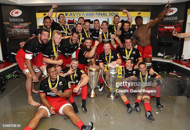 Saracens players celebrate with the trophy in the dressing room after the Aviva Premiership final match between Saracens and Exeter Chiefs at...