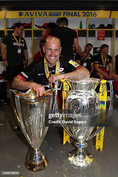 Charlie Hodgson of Saracens celebrates with the European Cup and Aviva Premiership trophies after the Aviva Premiership final match between Saracens...