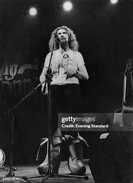 Scottish comedian Billy Connolly performing on stage in a pair of outsize, banana-shaped boots, 7th July 1977.
