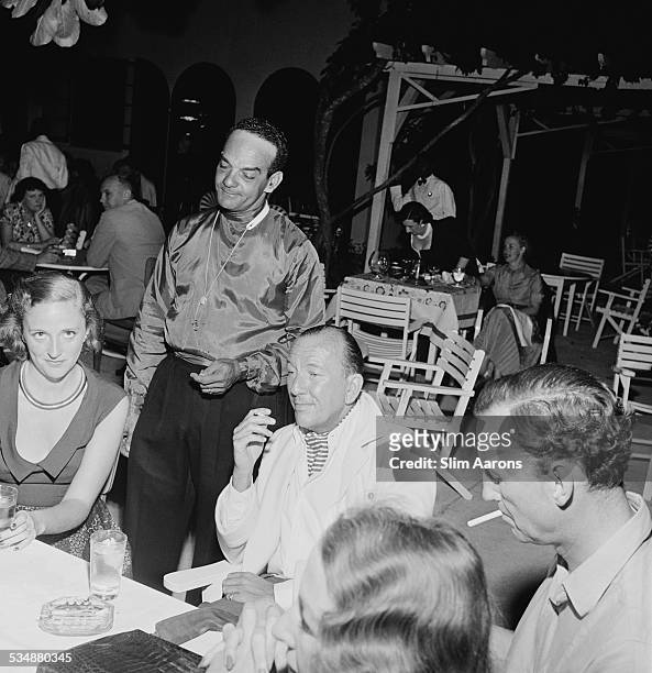 English singer, songwriter, actor and playwright Noel Coward with friends at Sunset Lodge, Jamaica, circa 1953. With him are Pam Akers and British...