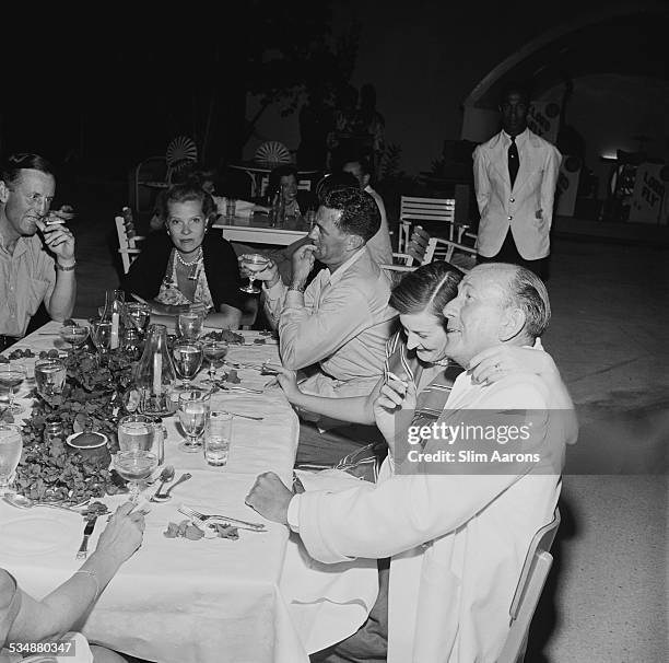 English singer, songwriter, actor and playwright Noel Coward with friends at Sunset Lodge, Jamaica, circa 1953. With him are British author Ian...