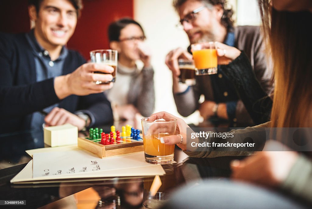 Group of friends toasting with drinks at home