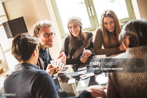 gruppo di amici brindando con bevande a casa - card game foto e immagini stock