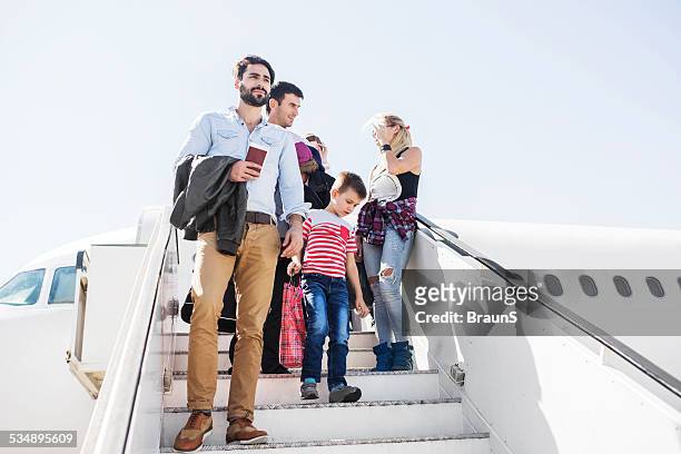 people disembarking the plane. - family tree stockfoto's en -beelden