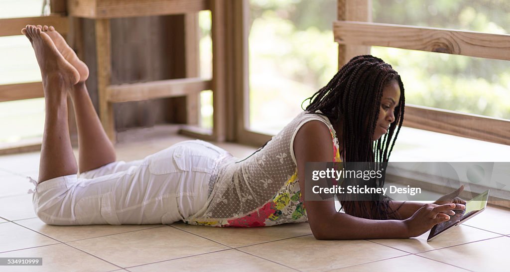 Woman using digital tablet outdoors on floor