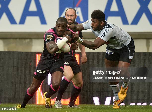 Stade Francais Paris' French fullback Djibril Camara is tackled during the French Top 14 rugby union match between Agen and Stade Français on May 28,...
