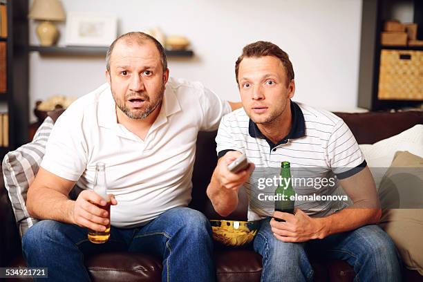 friends watching tv - bad news on tv stock pictures, royalty-free photos & images