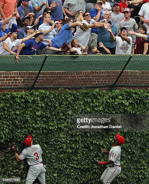 Fans scramble for a home run ball hit by Dexter Fowler of the Chicago Cubs as David Lough and Odubel Herrera of the Philadelphia Phillies watch in...