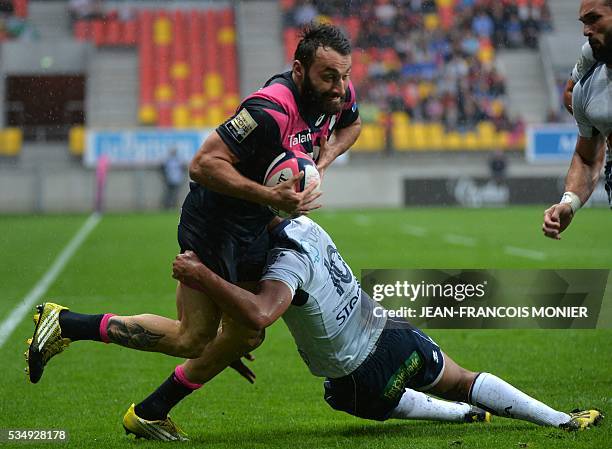 Stade Francais Paris' Jeremy Sinzelle is tackled after the French Top 14 rugby union match between Agen and Stade Français on May 28, 2016 at the...