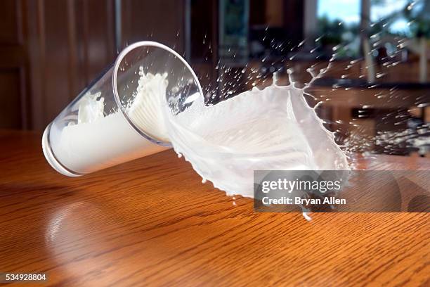 glass of milk spilling - glass of milk stock pictures, royalty-free photos & images