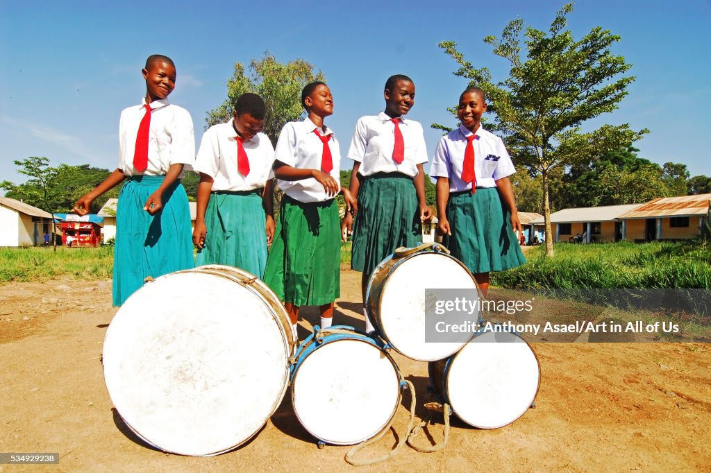 Tanzania, Mwanza, schoolchildren dancing and playing drum in schoolyard