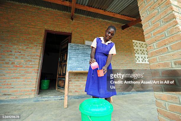 Malawi, Mzimba district, Thundwe Primary School, 13 year old Standard 6 pupils at Thundwe Junior Primary School, Salome Ndhlovu drinks water from a...