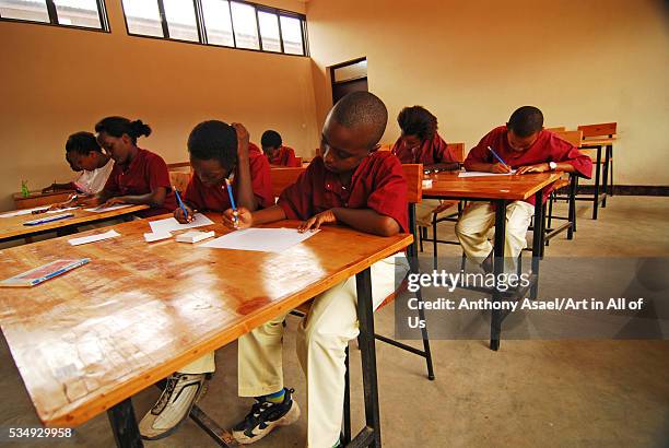 Burundi, Bujumbura, school kids writing exam papers in classroom