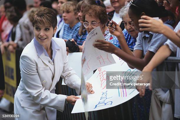 Katie Couric signs a homemade poster for a fan ourside of the Today Show set in Manhattan.