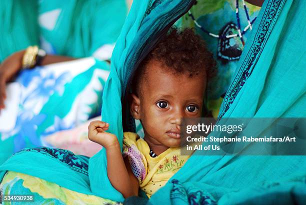 Djibouti, Balho, malnourished baby in the hand of mother with colorful veil