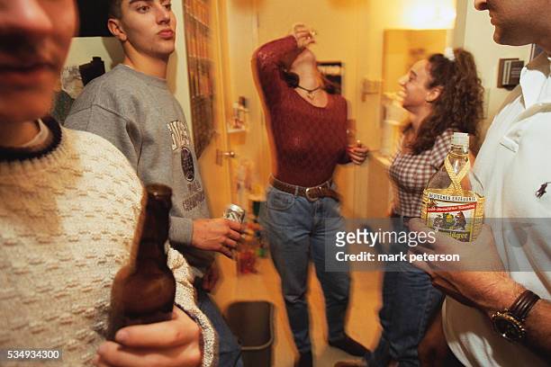 Young woman drinks a shot of alcohol at a party at Manzanita Residence Hall Dormitory at Arizona State University.