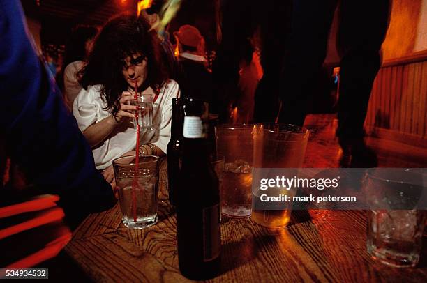 Woman drinks alcohol at a table in Club Rio, a popular hangout for Arizona State University students.