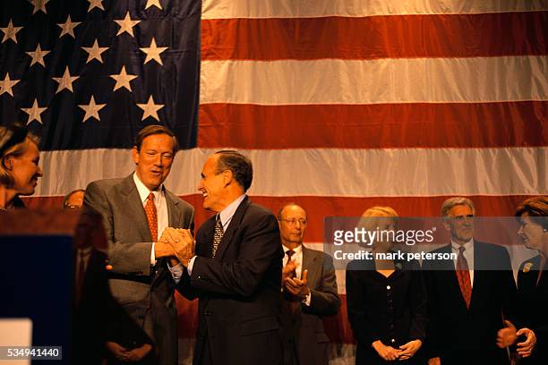 George Pataki and Rudy Giuliani shake hands at a fundraising dinner for Governor George Bush at the Sheraton Hotel. Also in attendance are Alfonse...