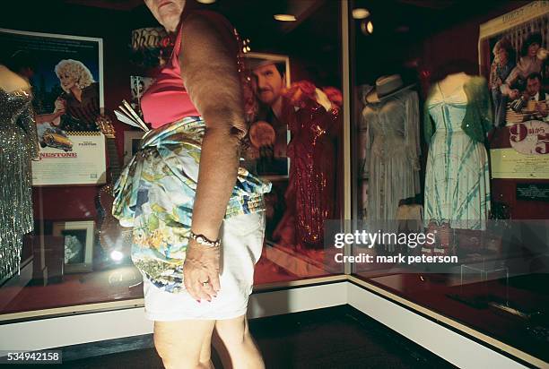 Woman Browsing an exhibit of Dolly Parton Costumes