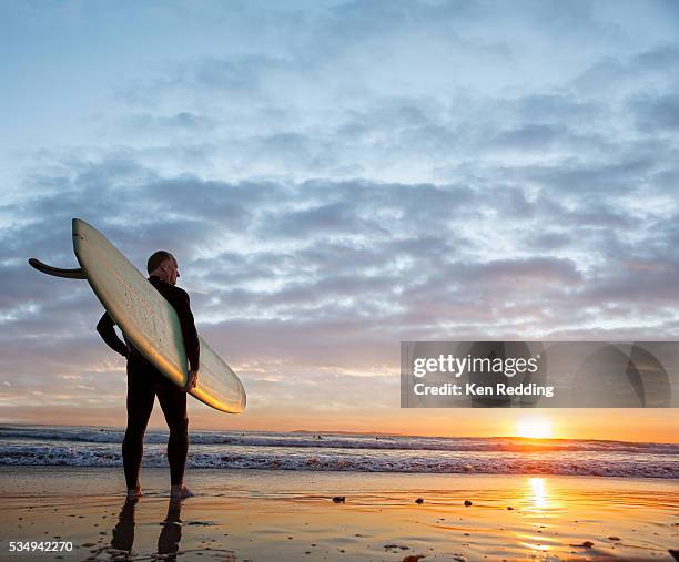man with surfboard - surfer sunset stock pictures, royalty-free photos & images