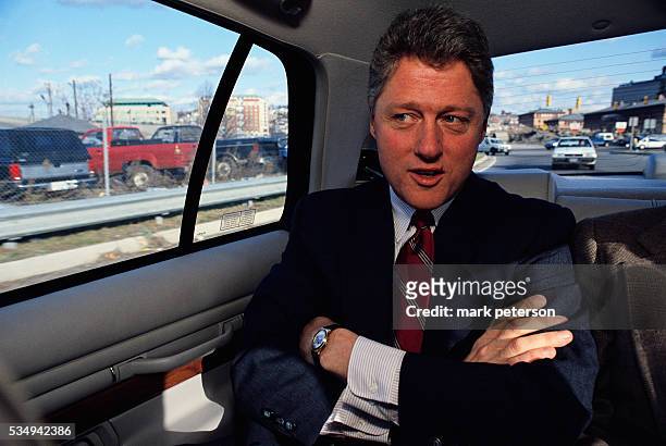 Presidential candidate Bill Clinton rides in a car on his way to a campaign stop in Rhode Island. Clinton would win the 1992 presidential election...