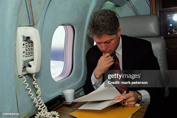 Presidential candidate Bill Clinton reviews paperwork while flying to Rhode Island for a campaign tour.
