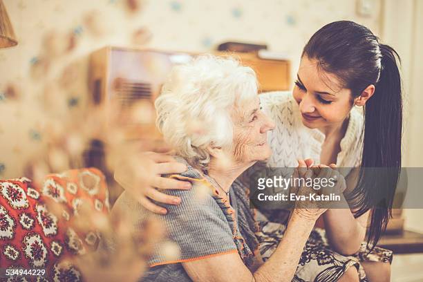 enkelin umarmen ihr glückliche großmutter wie zu hause fühlen. - teenager alter stock-fotos und bilder