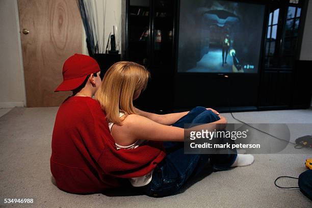 Boy and Girl Cuddling in Front of Television