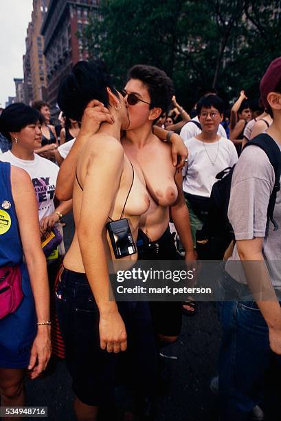Barebreasted lesbian couple kisses on a Manhattan street during the twenty-fifth anniversary celebration of the Stonewall Uprising. On June 26, 1969...