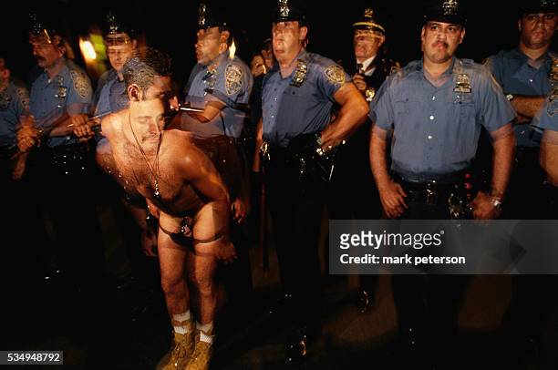 Gay man strips in front of a row of police officers during the twenty-fifth anniversary celebration of the Stonewall Uprising. On June 26, 1969 gay...