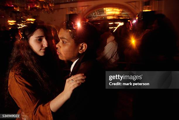 Adolescent girls and boys dance together at a bat mitzvah celebration for 13-year-old Ali Green. The reception takes place at a ballroom on...