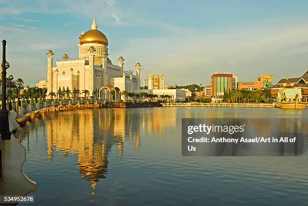 Brunei Darussalam, Bandar Seri Begawan, Sultan Omar Ali Saifuddin mosque reflecting in the water, the city center in the background, with modern and...