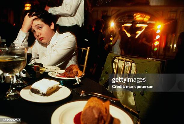 Tired Boy Resting at Table During Bar Mitzvah