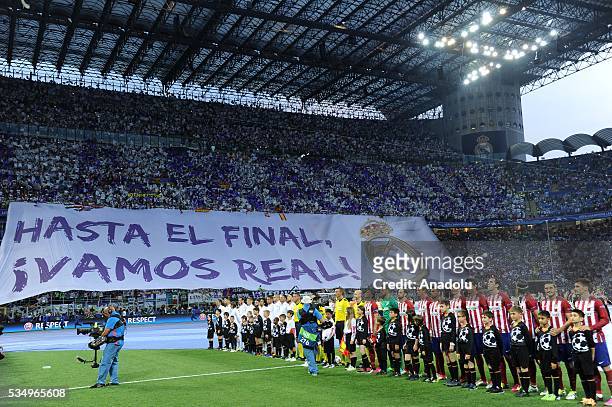 Players stand during the anthem singing ceremony prior to the UEFA Champions League Final between Real Madrid CF and Atletico Madrid at the Giuseppe...