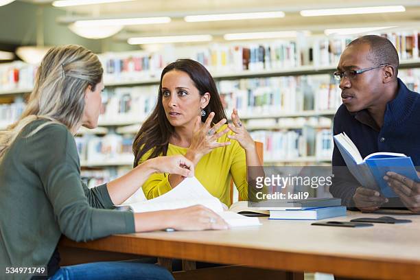 adult students studying  together in library - small group of people stock pictures, royalty-free photos & images