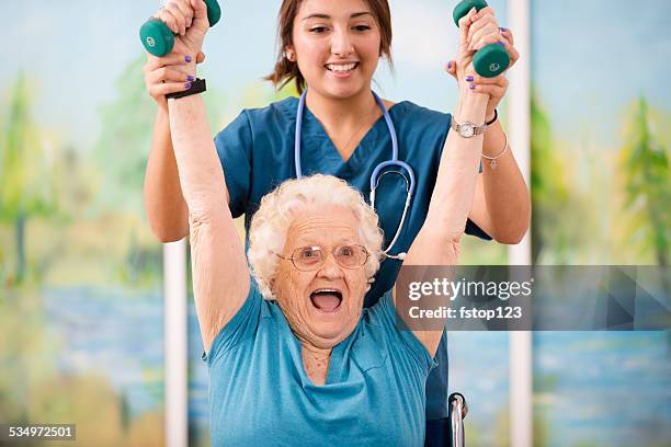 nurse does physical therapy with senior woman patient. arm strengthening. - 101 stockfoto's en -beelden