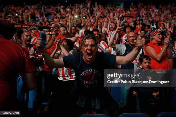 Atletico de Madrid fans react after their team scored its first goal as they watch the UEFA Champions League Final match between Real Madrid CF and...