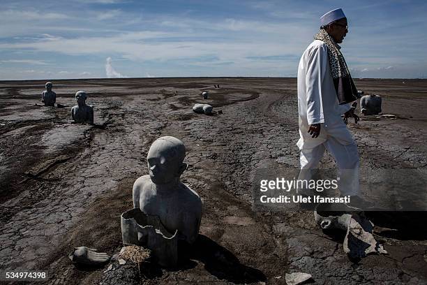 Man walks past Survivor statues displayed at mudflow areas to signify the lives of victims on May 27, 2016 in Sidoarjo, East Java, Indonesia. On 29...