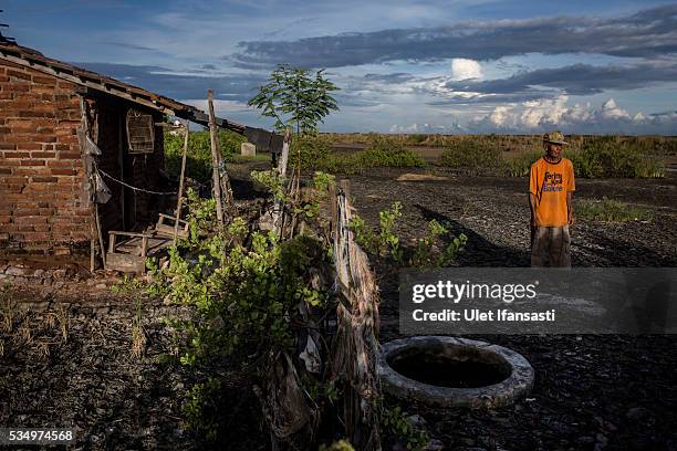 Suwadi , stands behind his house affected by mudflow on May 27, 2016 in Sidoarjo, East Java, Indonesia. On 29 May a mudflow eruption began in the...