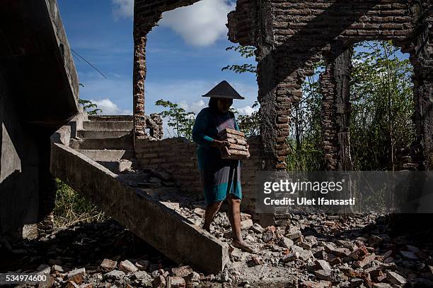 Woman works on the demolition site of a house on May 27, 2016 in Sidoarjo, East Java, Indonesia. On 29 May a mudflow eruption began in the Sidoarjo...