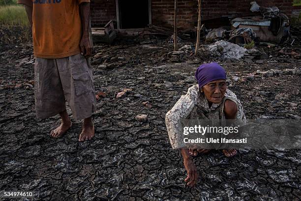Suwadi and his wife, Saniaka , stand behind their house which is affected by mudflow on May 27, 2016 in Sidoarjo, East Java, Indonesia. On 29 May a...